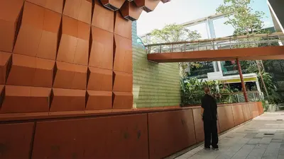 a man standing on a sidewalk in front of a building at Beach Haus Design District in Miami