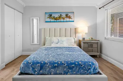 a bedroom with a large bed with a blue blanket at Riverbend Apartments by Lowkl in Fort Lauderdale