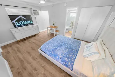 a bedroom with a bed and a dresser and a tv at Riverbend Apartments by Lowkl in Fort Lauderdale