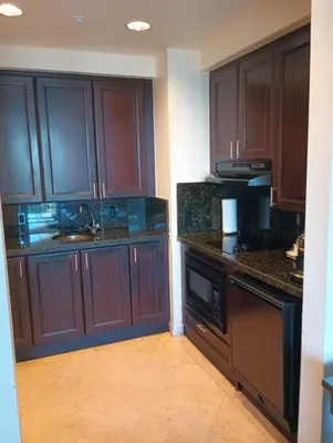 a kitchen with brown cabinets and a sink and a dishwasher at Private Residences at The Atlantic Resort & Spa in Fort Lauderdale