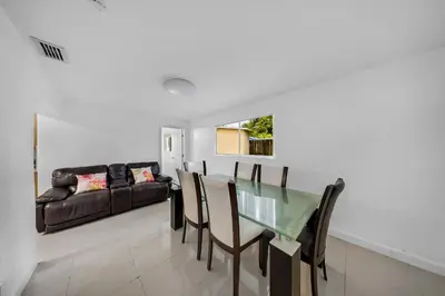 a dining room with a glass table and a couch at Casa Neisy Florida 10 minutes from Hollywood Beach and Hard Rock Hotel & Casino Hollywood in Hollywood