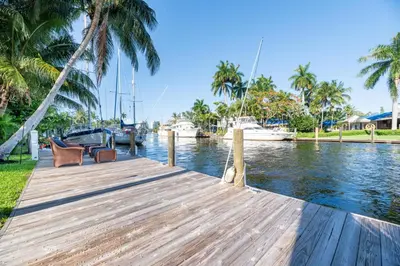 a wooden dock with chairs and boats in a marina at The Riverside Retreat 1 in Fort Lauderdale