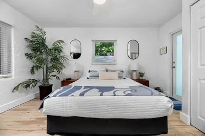 a bedroom with a large bed and two mirrors at The Riverside Retreat 2 in Fort Lauderdale
