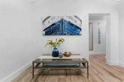 a table in a living room with a painting on the wall at The Riverside Retreat 2 in Fort Lauderdale