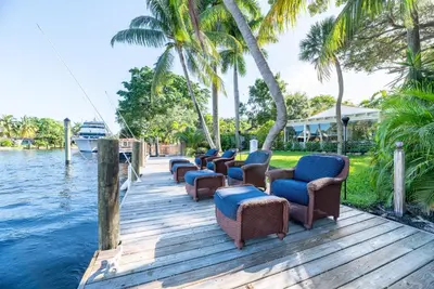 a row of chairs on a dock next to the water at The Riverside Retreat 2 in Fort Lauderdale
