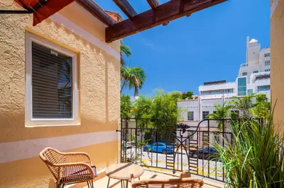 a balcony with chairs and tables and a view of a street at Kasa La Flora And Impala Miami Beach in Miami Beach