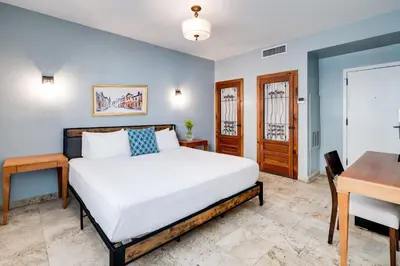 a bedroom with a bed and a desk at Kasa La Flora And Impala Miami Beach in Miami Beach