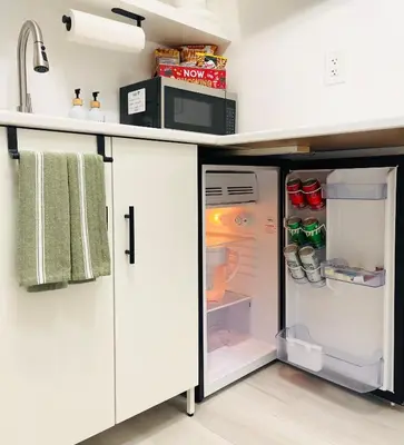 a kitchen with an open refrigerator and a microwave at Guesthouse w Bikes near Wynwood in Miami