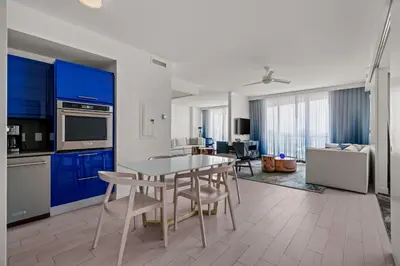 a kitchen with blue cabinets and a table and chairs at 2BR Fort Lauderdale W Residence with Double Living Room, Ocean & Intercoastal Views, Brand New Sofas! in Fort Lauderdale