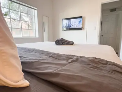 a bed with a bag sitting on top of it at Dos Casitas Design District #1 - 3 Bedroom House in Miami