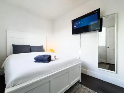 a bedroom with a bed with a flat screen tv on the wall at Dos Casitas Design District #1 - 3 Bedroom House in Miami