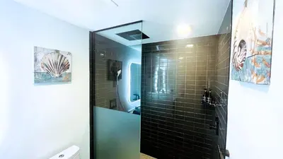 a bathroom with a shower with black tiled walls at Sky-High oasis Large Studio POOL & GYM in Miami