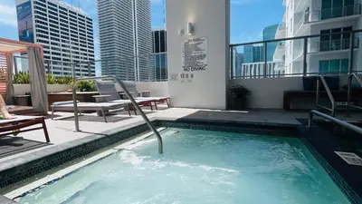 a swimming pool on the rooftop of a building at Sky-High oasis Large Studio POOL & GYM in Miami