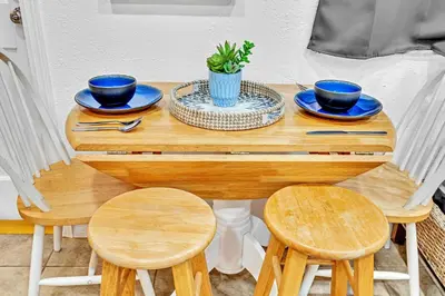 a wooden table with two chairs and blue dishes on it at Beachfront & Pool Access Unit W 2 Queen Beds in Hollywood