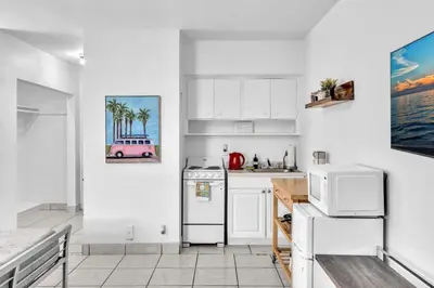 a kitchen with white cabinets and a pink car on the wall at Studio Retreat With 2 Queen Beds Hollywood Blvd in Hollywood