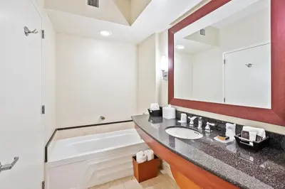 a bathroom with a sink and a tub and a mirror at Trump International Beach Resort Deluxe 2 Queen Ocean Front in Sunny Isles Beach