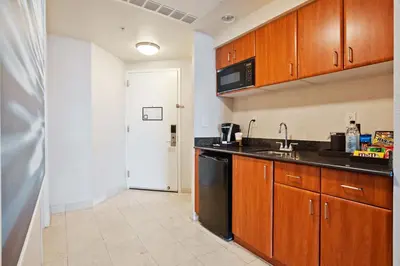 a kitchen with wooden cabinets and a black dishwasher at Trump International Beach Resort Deluxe 2 Queen Ocean Front in Sunny Isles Beach