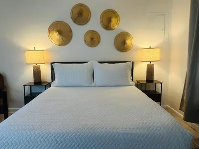 a bedroom with a bed with two lamps and three plates on the wall at Wilton Manors Guesthouse in Fort Lauderdale