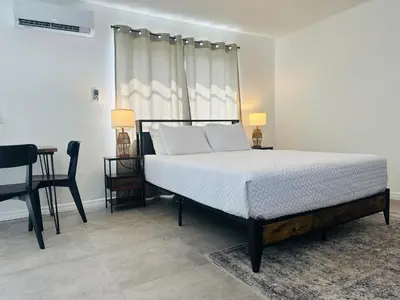 a bedroom with a bed and a table and a chair at Wilton Manors Guesthouse in Fort Lauderdale