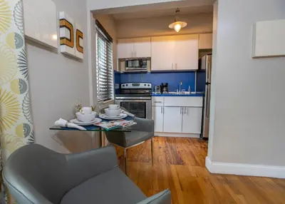 a small kitchen with a table and a chair at Beachside All Suites Hotel in Miami Beach