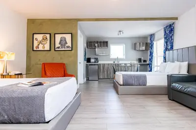 a hotel room with two beds and a kitchen at Beachside All Suites Hotel in Miami Beach