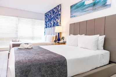 a bedroom with two beds and a window at Beachside All Suites Hotel in Miami Beach