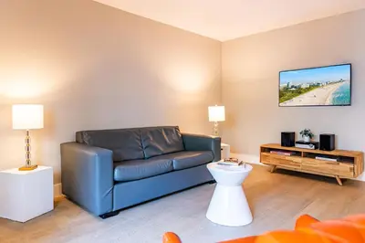 a living room with a blue couch and a table at Beachside All Suites Hotel in Miami Beach