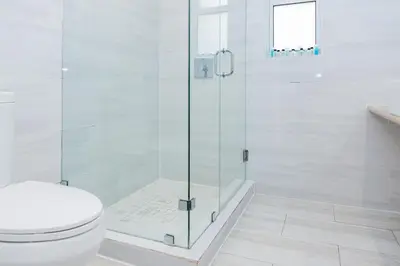 a bathroom with a toilet and a glass shower at Beachside All Suites Hotel in Miami Beach