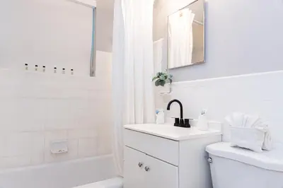 a white bathroom with a sink and a tub at Beachside All Suites Hotel in Miami Beach