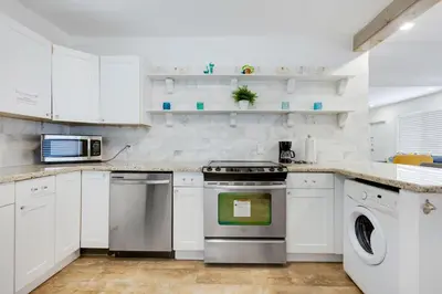 a white kitchen with a stove and a dishwasher at ULTRA chic apartment steps from the beach in Hollywood
