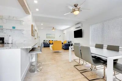a dining room and living room with a table and chairs at ULTRA chic apartment steps from the beach in Hollywood