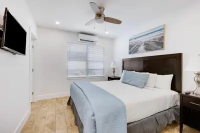 a bedroom with a bed and a flat screen tv at ULTRA chic apartment steps from the beach in Hollywood