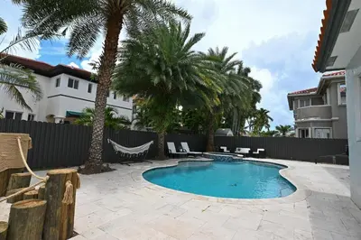 a swimming pool in a yard with palm trees at LuxOasis Getaway Minigolf, Pool, Beach, Chess, Jacuzzi in Tamiami
