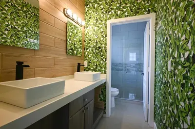 a bathroom with a sink and a green wall at LuxOasis Getaway Minigolf, Pool, Beach, Chess, Jacuzzi in Tamiami