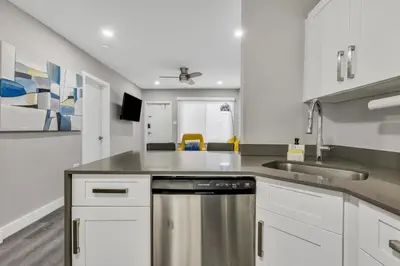 a kitchen with white cabinets and a stainless steel dishwasher at ULTRA magical apartment at the Beach in Hollywood