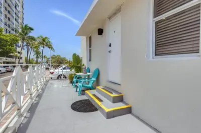 a porch with two blue chairs and a door at ULTRA magical apartment at the Beach in Hollywood