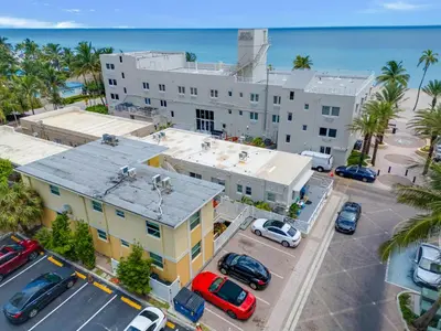 an aerial view of a building with cars parked in a parking lot at ULTRA spacious apartment steps from the beach in Hollywood