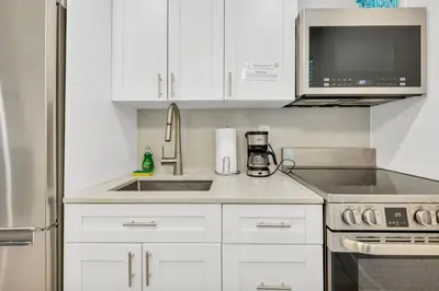 a kitchen with white cabinets and a sink at ULTRA joyful apartment perfect for families in Hollywood