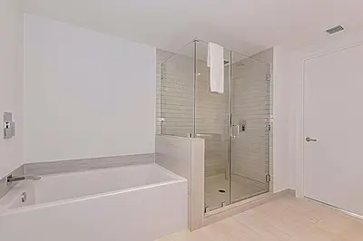 a white bathroom with a glass shower stall at Luxury 2 Br Oceanfront Balcony Beautiful Amenities in Hollywood