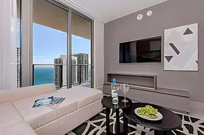 a living room with a couch and a large window at Luxury 2 Br Oceanfront Balcony Beautiful Amenities in Hollywood
