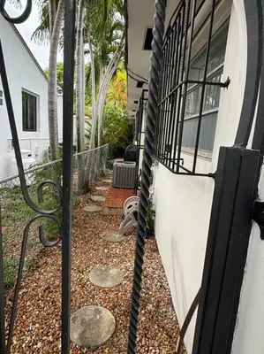 a gate to a house with palm trees at LaBella Suite in Miami