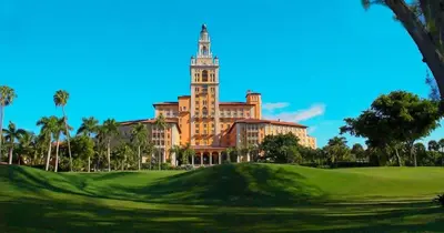 a large building with a tower on top of a green at LaBella Suite in Miami
