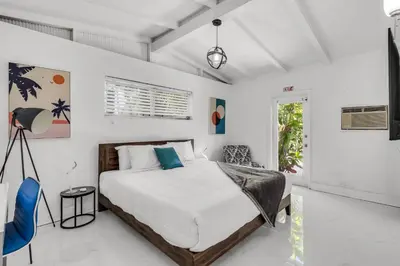 a bedroom with a large bed in a white room at Ventur Tropical with Elite Pool & Ultimate Fun Zone in Fort Lauderdale