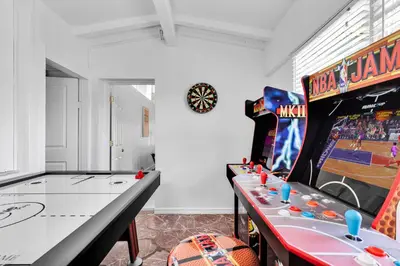 a gaming room with a pinball machine and a table at Ventur Tropical with Elite Pool & Ultimate Fun Zone in Fort Lauderdale