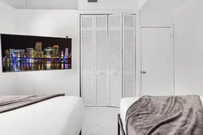 a bedroom with a bed and a picture of a city at Ventur Tropical with Elite Pool & Ultimate Fun Zone in Fort Lauderdale