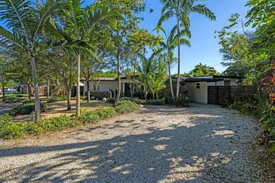 a driveway leading to a house with palm trees at Ventur Tropical with Elite Pool & Ultimate Fun Zone in Fort Lauderdale