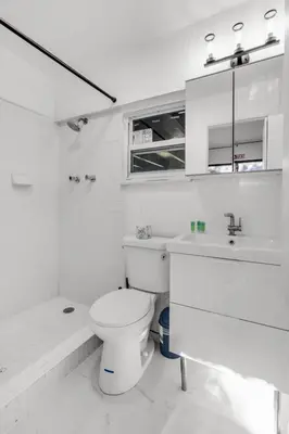 a white bathroom with a toilet and a sink at Ventur Tropical with Elite Pool & Ultimate Fun Zone in Fort Lauderdale