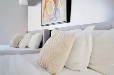 a bedroom with a bed with white pillows and a couch at 2 bed condo, Queen sofa bed Brickell, Free Parking, Pool, Gym in Miami