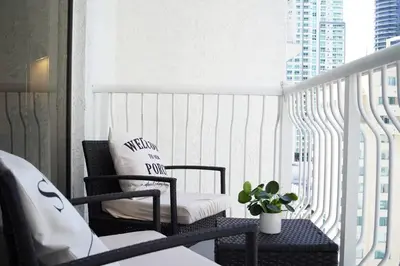 a balcony with a chair and a couch on a balcony at 2 bed condo, Queen sofa bed Brickell, Free Parking, Pool, Gym in Miami