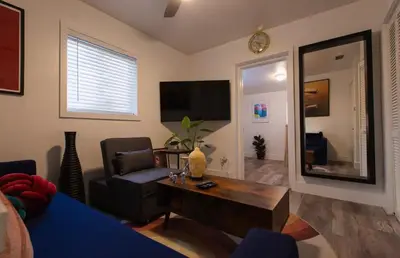 a living room with a couch and a table and a tv at The Myrlande Dinvil Guest Suite in North Miami Beach